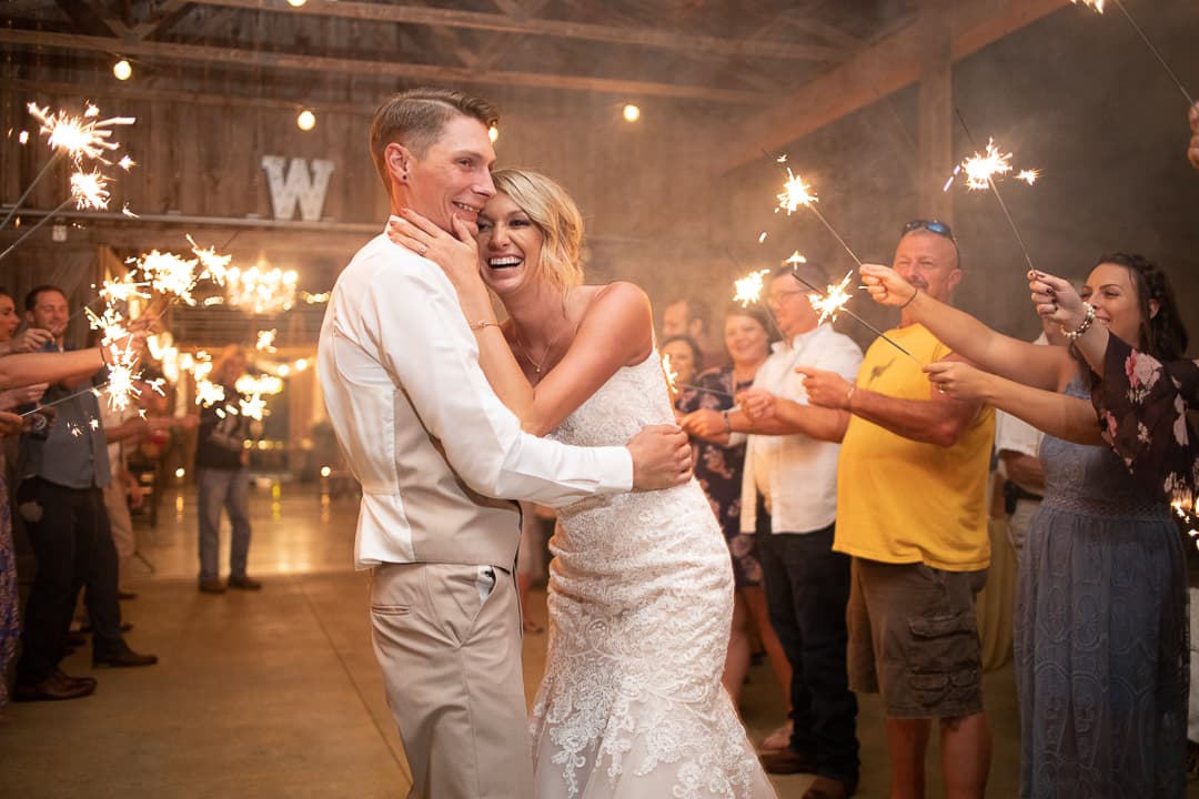 A couple laughing together as sparklers light the room